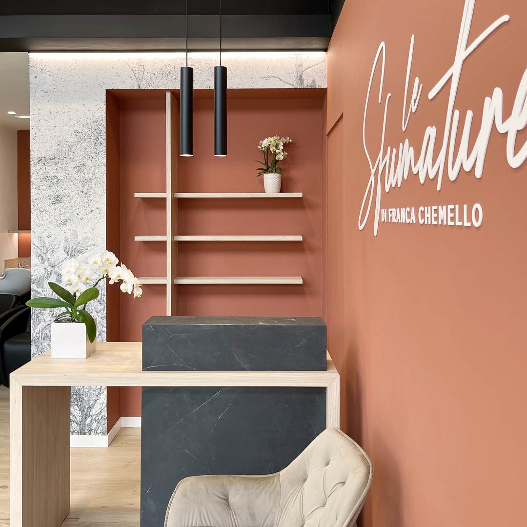 immagine Area reception con mobili in legno e neri. Pareti color Mattone
